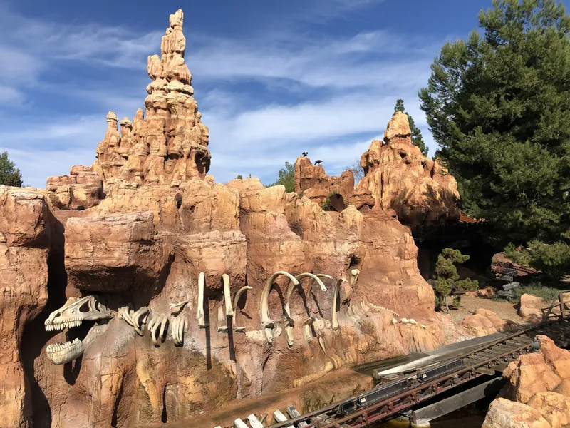 Red rock spires of Big Thunder Mountain with dinosaur bones along the track
