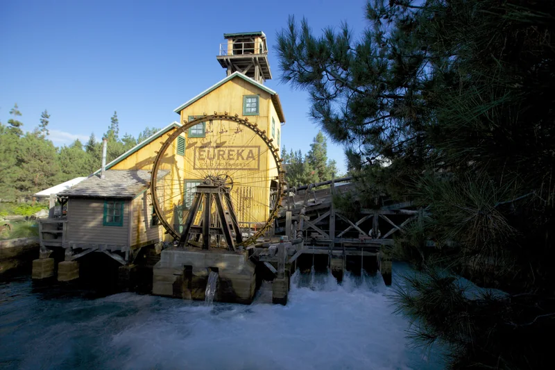 Yellow Eureka Company mill and waterwheel above rushing water