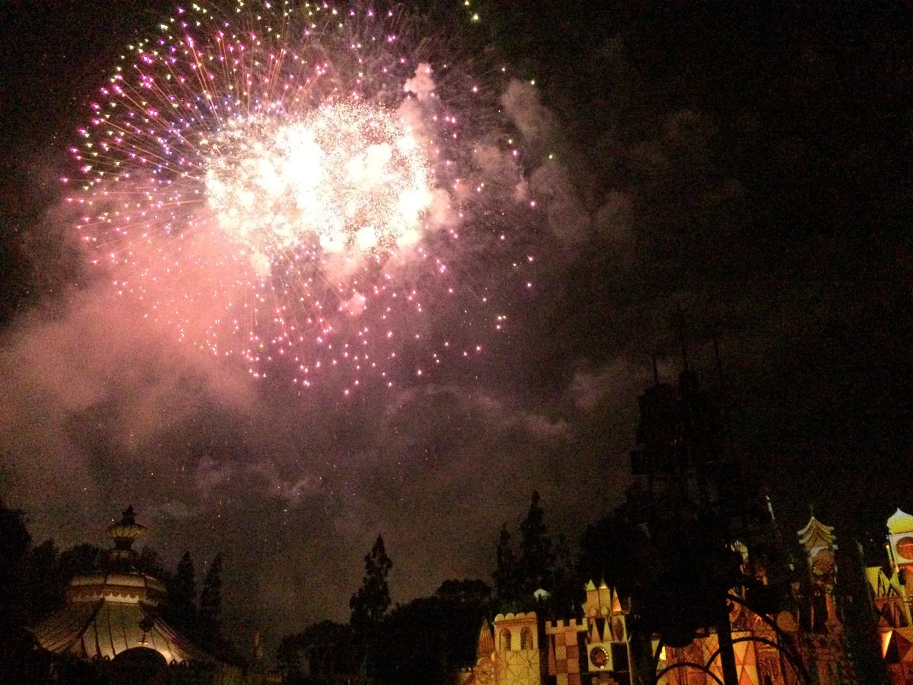 Pink and gold fireworks above the castle rooftops at night