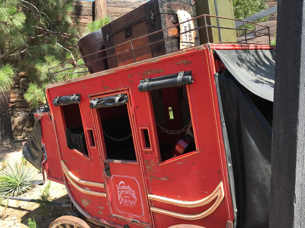 A red Disneyland Railroad carriage among green trees