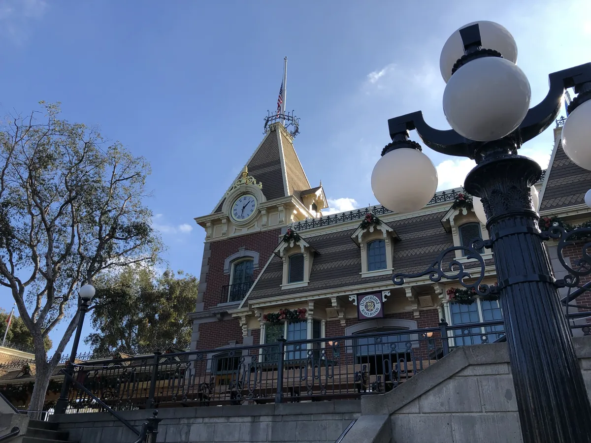 The Main Street Station clock tower at Disneyland behind an iron lamp post