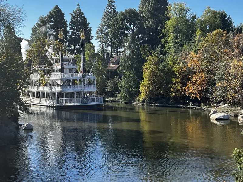 The Mark Twain Riverboat on the Rivers of America, framed by autumn trees