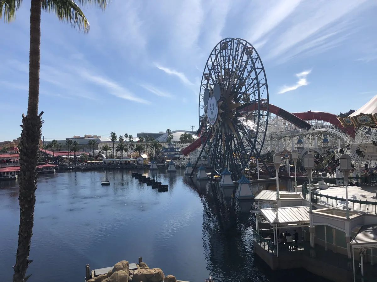 The Pixar Pal-A-Round Ferris wheel and the Incredicoaster track beside the water at Pixar Pier