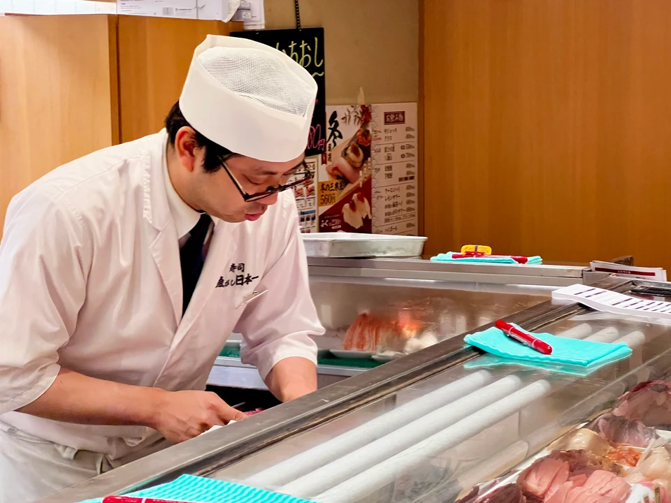 Sushi chef preparing nigiri at a Japanese sushi counter