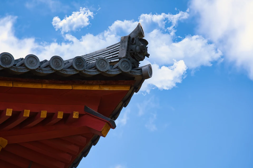 Ornamental roof tiles of a Japanese temple with blue sky